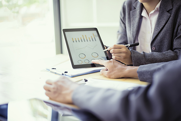 Business people analyzing investment charts with teblet in meeting room, Accounting concept, soft focus, vintage tone